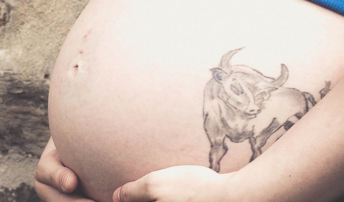 Gravid kvinna med tatuering på magen