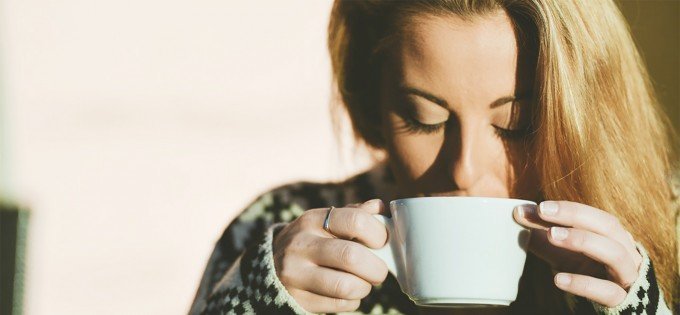 Kvinna dricker morgonkaffe.