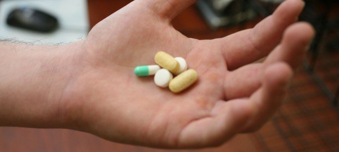 En öppen hand håller fem olika piller.