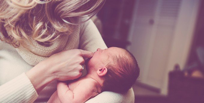 Mamma som håller sin nyfödda bebis. En stressad mamma kan utsätta sitt foster för samma känslor enligt ny studie.