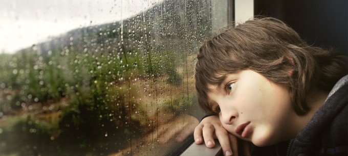 Deprimerad pojke på ett tåg.