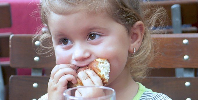 Litet barn som äter vitt bröd. En ny undersökning har klurat ut hur man kan stoppa framtida fetmaepidemi med hjälp av att mäta barns BMI.