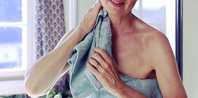 Kvinna som torkar sig med en handduk. FOrskare anser nu att man bör tvätta handduken var tredje dusch för att slippa smuts och bakterier.