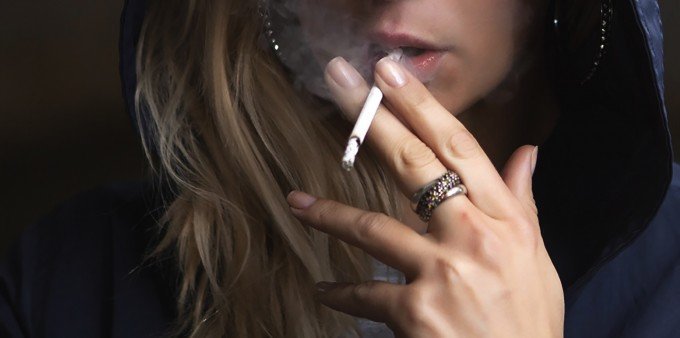 Kvinna som röker en cigarett.