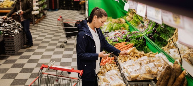 Kvinna handlar grönsaker i en butik